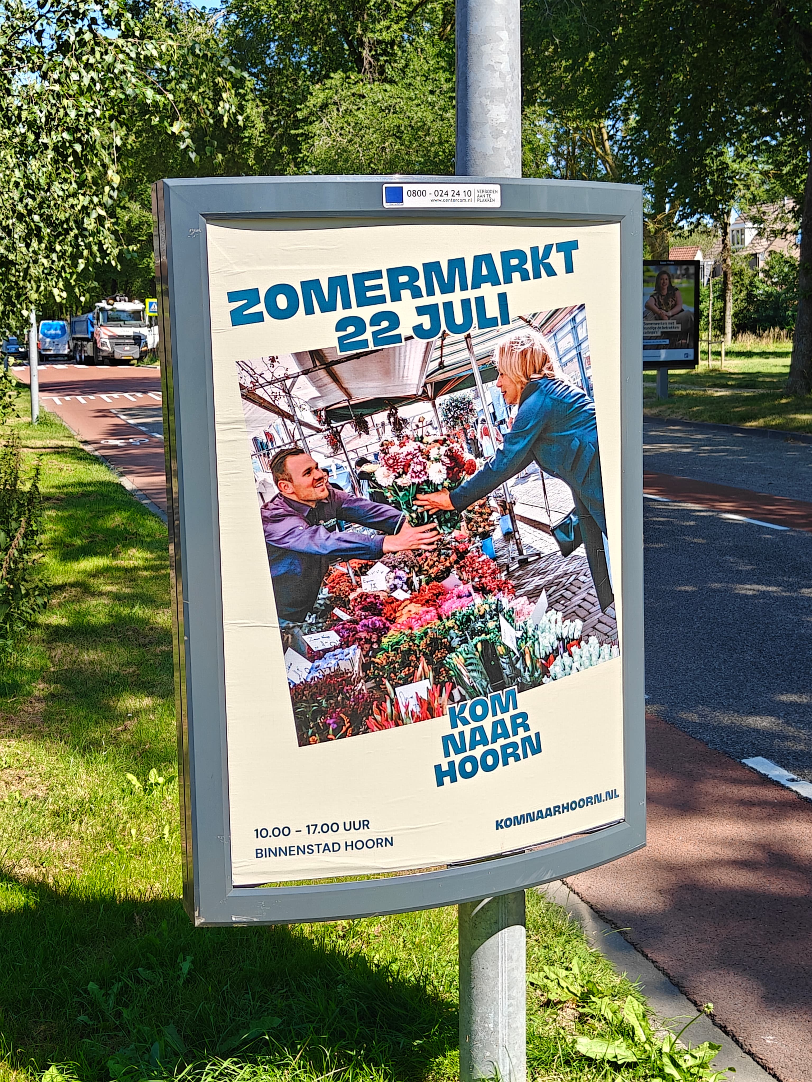 Verlichte mupi met een campagneposter langs de weg in Hoorn
