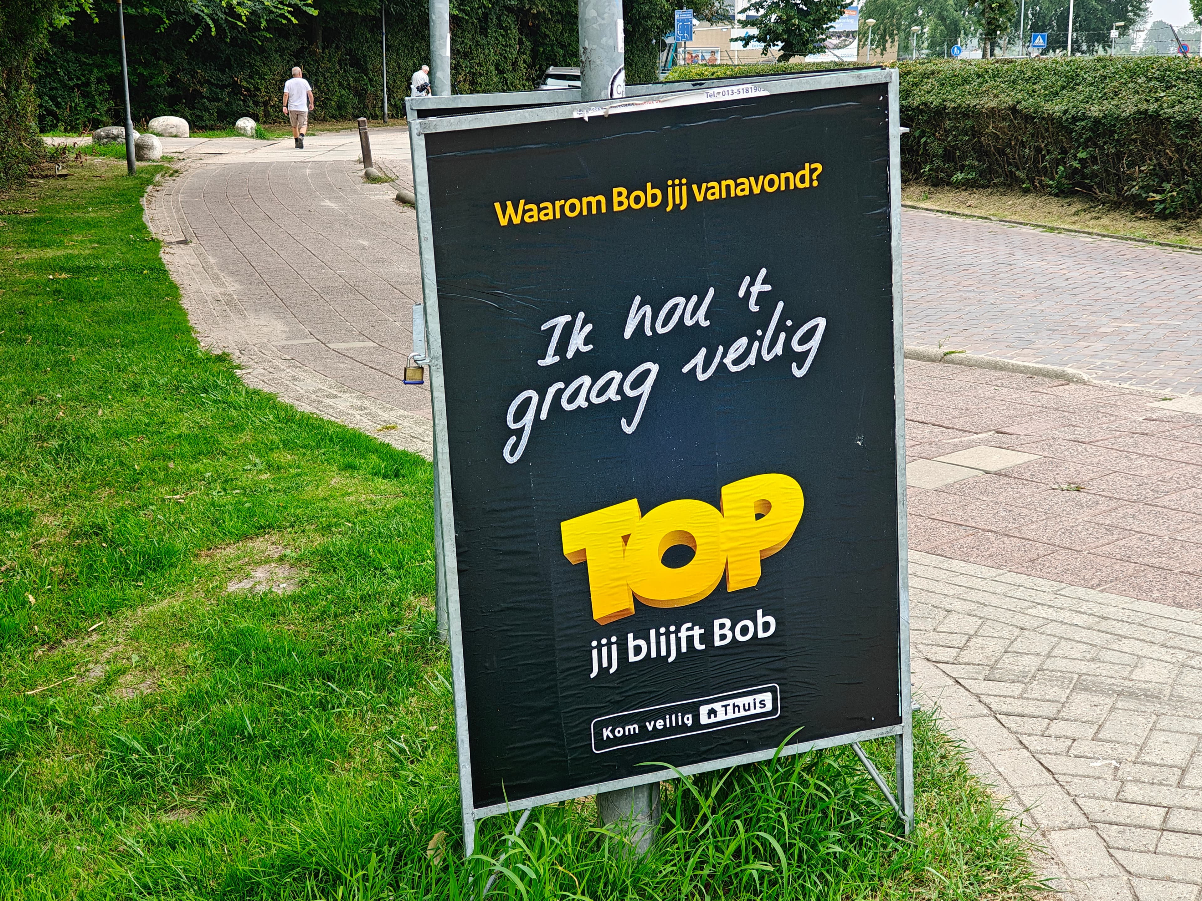 Sandwichbord met een campagne langs een wandelpad in de stad
